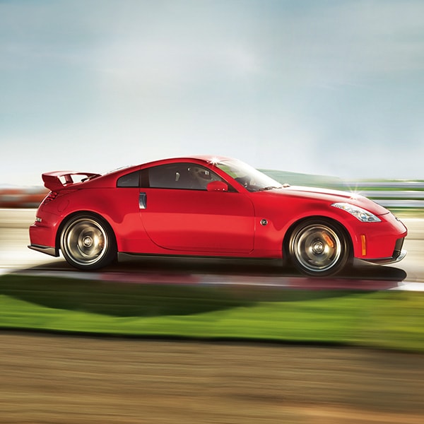 side view of Red 2024 Nissan NISMO Z speeding down country road