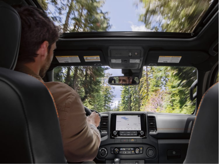 View of trees out windshield and sunroof 2024 Nissan Frontier
