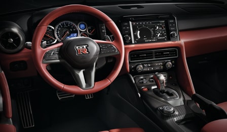  2024 Nissan GT-R interior view of driver's seat, steering wheel and instrument panel.