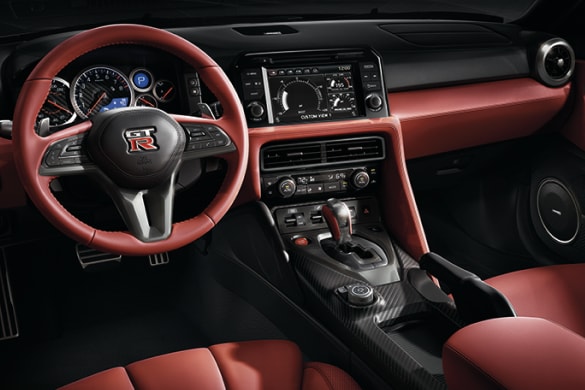 Vue intérieure de la Nissan GT-R 2024 montrant le tableau de bord inspiré d’un poste de pilotage.